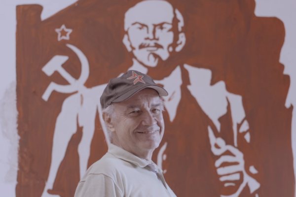 Hombre con imagen de Lenin a sus espaldas