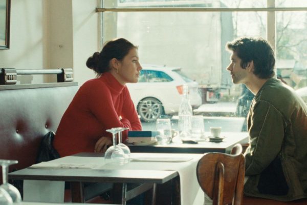 Un hombre y una mujer sentados frente a frente en una mesa